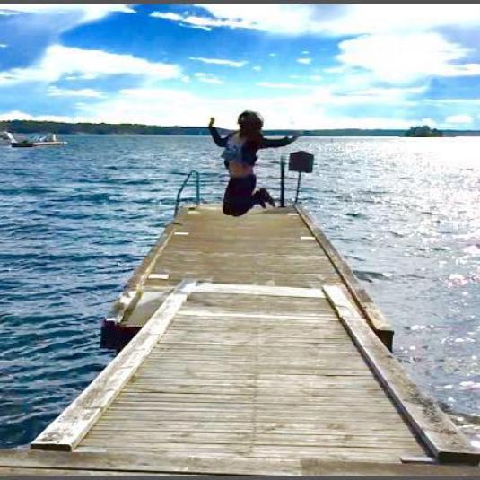 A traveller with arms outstretched at the end of a wooden jetty