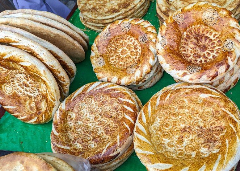 What to eat in uzbekistan: Uzbek Bread while baking ad eating together
